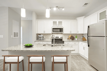 A kitchen with a granite countertop and white cabinets.